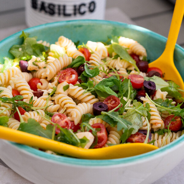 Ensalada italiana de pasta fría con tomates cherry, mozzarella y rúcula