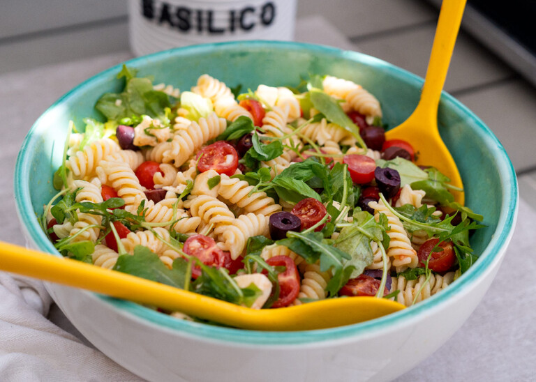Ensalada italiana de pasta fría con tomates cherry, mozzarella y rúcula