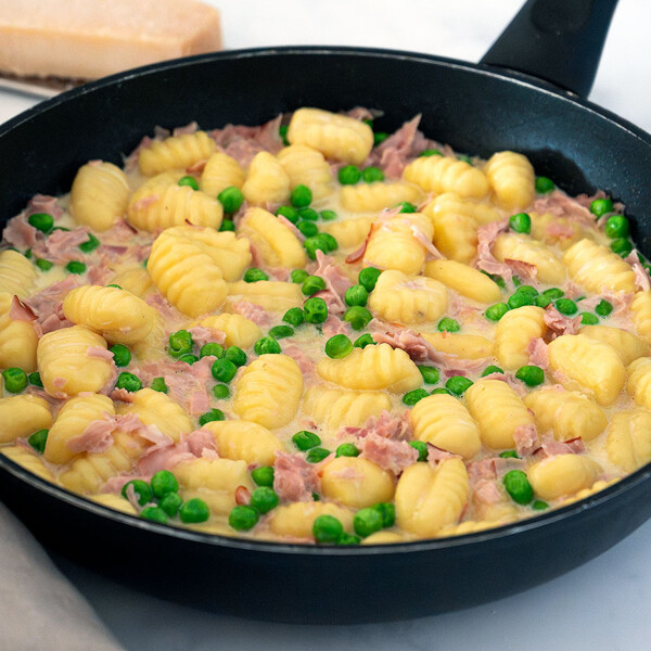 Ñoquis con nata, jamón y guisantes